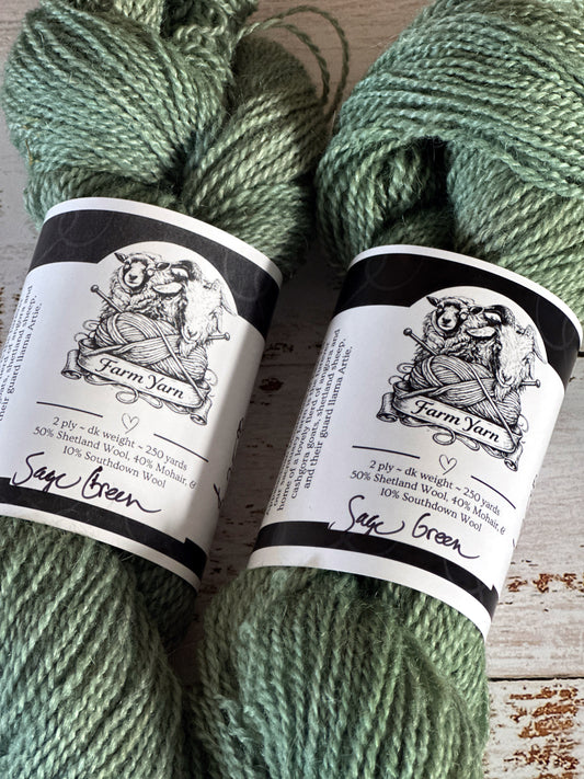 Two skeins of green yarn with labels on a wooden surface